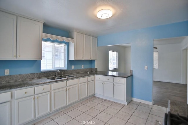 531 W 61st St, Los Angeles, CA 90044 - kitchen featuring light tile patterned flooring, dark countertops, and white cabinetry