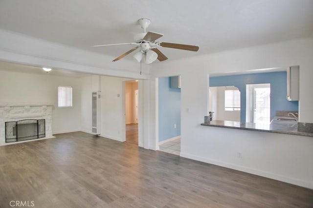 531 W 61st St, Los Angeles, CA 90044 - unfurnished living room with a heating unit, a premium fireplace, a ceiling fan, and plenty of natural light