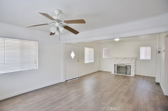 531 W 61st St, Los Angeles, CA 90044 - unfurnished living room with wood finished floors, ceiling fan, and a high end fireplace