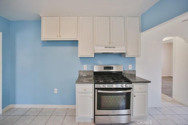 531 W 61st St, Los Angeles, CA 90044 - kitchen with stainless steel gas range, under cabinet range hood, white cabinets, and light tile patterned flooring