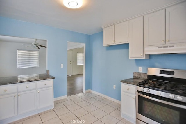 531 W 61st St, Los Angeles, CA 90044 - kitchen with stainless steel gas range, under cabinet range hood, white cabinets, and dark stone counters