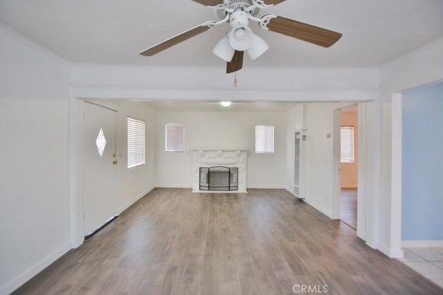 531 W 61st St, Los Angeles, CA 90044 - unfurnished living room with crown molding, a high end fireplace, a ceiling fan, and wood finished floors