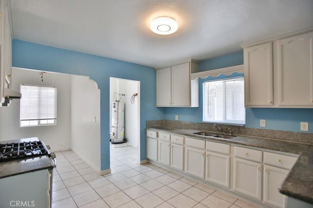 531 W 61st St, Los Angeles, CA 90044 - kitchen with strapped water heater, healthy amount of natural light, dark countertops, and light tile patterned floors