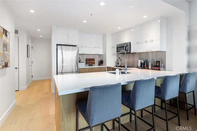 400 S Broadway Unit 1701, Los Angeles, CA 90013 - kitchen with appliances with stainless steel finishes, a peninsula, white cabinetry, modern cabinets, and light countertops