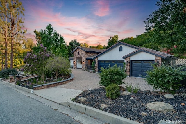 235 Verbena Ln, Brea, CA 92823 - ranch-style home with an attached garage, stucco siding, stone siding, and decorative driveway