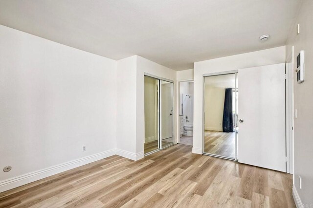 2850 Reynard Way Unit 10, San Diego, CA 92103 - unfurnished bedroom with light wood finished floors, two closets, and connected bathroom