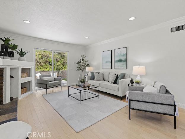 22601 Aguadero Pl, Saugus, CA 91350 - living room featuring crown molding, light wood-style floors, and recessed lighting