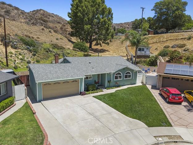 22601 Aguadero Pl, Saugus, CA 91350 - single story home with concrete driveway, a mountain view, a garage, a chimney, and a gate
