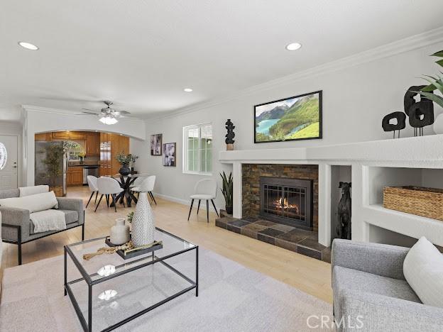 22601 Aguadero Pl, Saugus, CA 91350 - living room with crown molding, wood finished floors, a tile fireplace, a ceiling fan, and recessed lighting