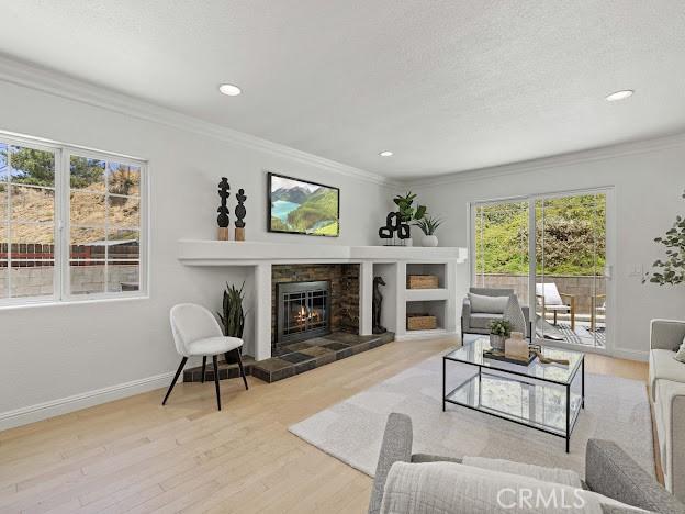 22601 Aguadero Pl, Saugus, CA 91350 - living area with a tile fireplace, plenty of natural light, wood finished floors, crown molding, and recessed lighting
