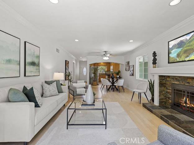 22601 Aguadero Pl, Saugus, CA 91350 - living area with ornamental molding, light wood finished floors, recessed lighting, a tile fireplace, and a ceiling fan