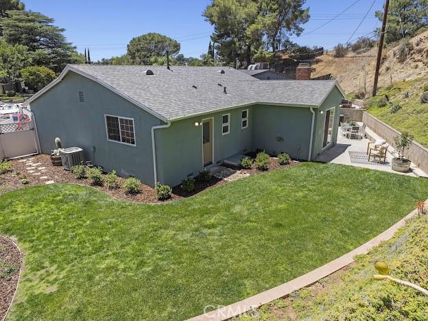 22601 Aguadero Pl, Saugus, CA 91350 - back of property featuring a patio, stucco siding, roof with shingles, and a chimney