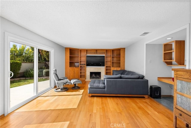 1317 Mill Creek Ct, Thousand Oaks, CA 91360 - living area featuring a textured ceiling, wood finished floors, a fireplace, and built in shelves