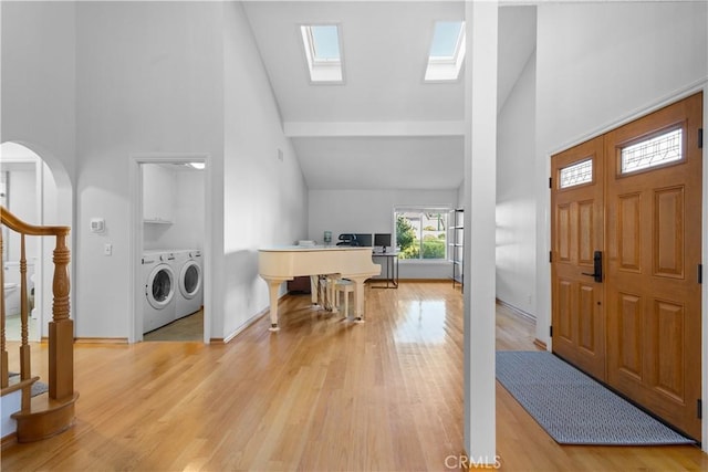 1317 Mill Creek Ct, Thousand Oaks, CA 91360 - foyer entrance featuring high vaulted ceiling, independent washer and dryer, light wood finished floors, a skylight, and stairway