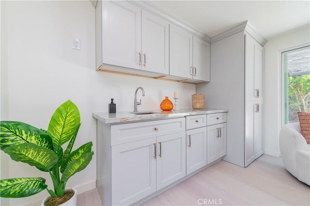 16645 Holton St, La Puente, CA 91744 - kitchen with light stone countertops, light wood-style flooring, and white cabinetry