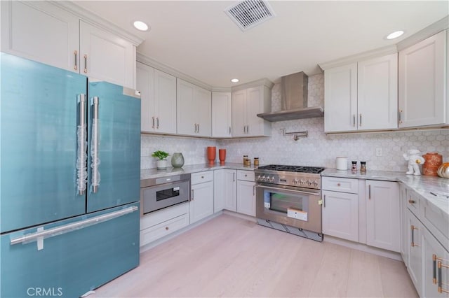 16645 Holton St, La Puente, CA 91744 - kitchen with high quality appliances, wall chimney range hood, light wood-style floors, backsplash, and recessed lighting