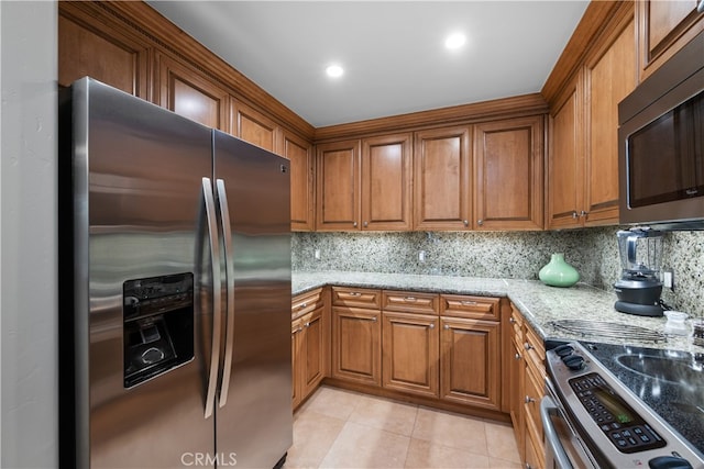 2727 Shell Beach Rd Unit 219, Pismo Beach, CA 93449 - kitchen featuring appliances with stainless steel finishes, brown cabinets, and light tile patterned floors