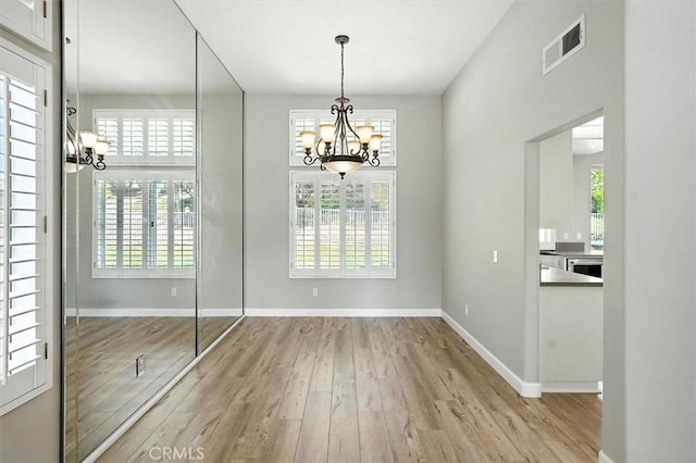25623 Frost Ln, Stevenson Ranch, CA 91381 - unfurnished dining area featuring a chandelier, wood finished floors, and healthy amount of natural light