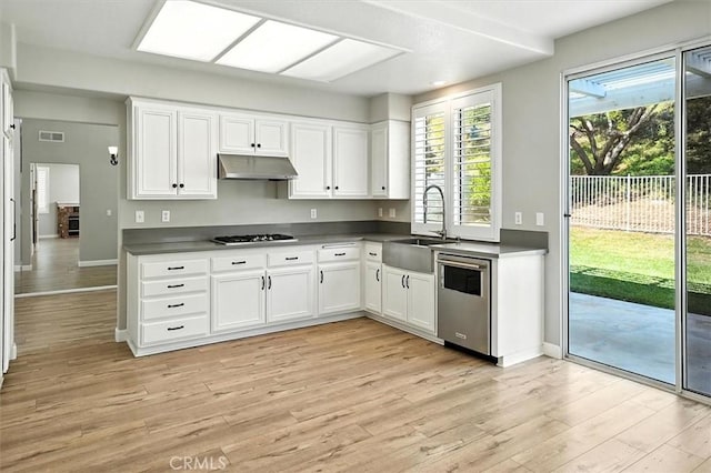 25623 Frost Ln, Stevenson Ranch, CA 91381 - kitchen with under cabinet range hood, dishwasher, light wood-style floors, white cabinetry, and gas stovetop
