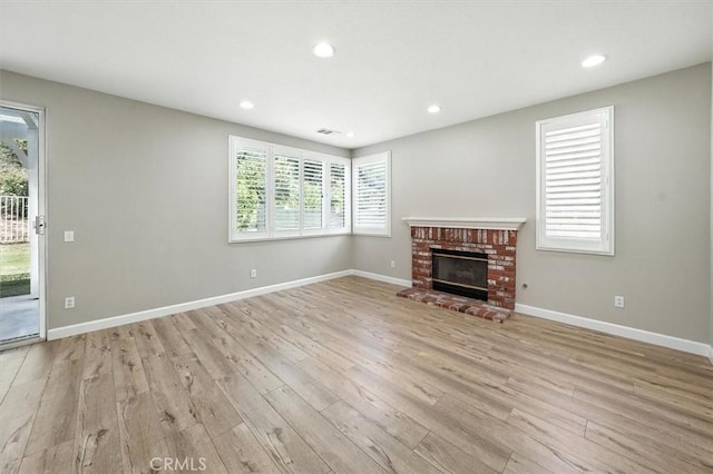 25623 Frost Ln, Stevenson Ranch, CA 91381 - unfurnished living room featuring light wood finished floors, plenty of natural light, a fireplace, and recessed lighting