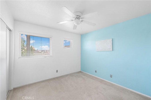 2659 Cold Creek Ave, Rosamond, CA 93560 - unfurnished bedroom featuring multiple windows, a closet, light carpet, and a ceiling fan