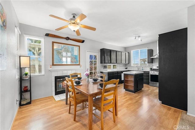 2659 Cold Creek Ave, Rosamond, CA 93560 - dining room featuring light wood-style floors, ceiling fan, and a fireplace