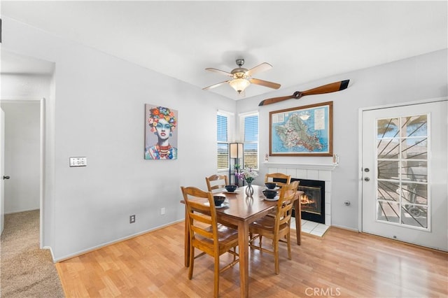 2659 Cold Creek Ave, Rosamond, CA 93560 - dining room with a tiled fireplace, ceiling fan, and light wood-type flooring