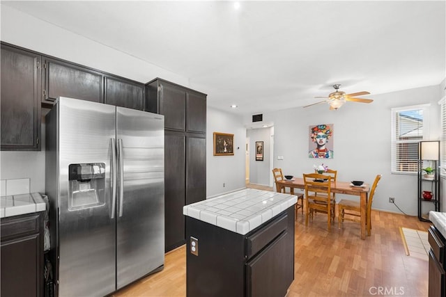 2659 Cold Creek Ave, Rosamond, CA 93560 - kitchen featuring stainless steel fridge with ice dispenser, tile countertops, ceiling fan, a center island, and light wood-style flooring