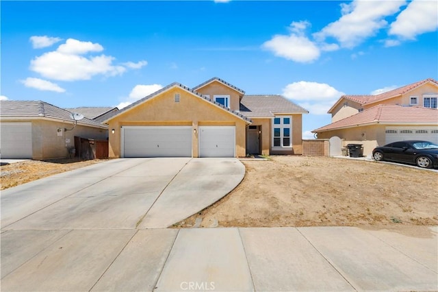 2659 Cold Creek Ave, Rosamond, CA 93560 - view of front of house featuring an attached garage, driveway, stucco siding, and a tile roof