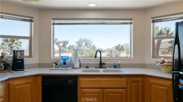 8920 Del Monte Ave, Yucca Valley, CA 92284 - kitchen featuring black appliances, healthy amount of natural light, light countertops, and brown cabinets