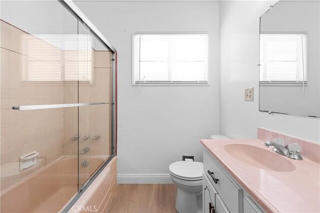 1256 Windsor Dr, San Bernardino, CA 92404 - full bathroom with vanity, wood finished floors, and shower / bath combination with glass door