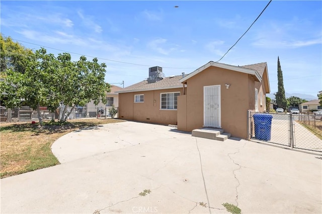 1256 Windsor Dr, San Bernardino, CA 92404 - back of property with stucco siding, a patio area, a gate, and roof with shingles