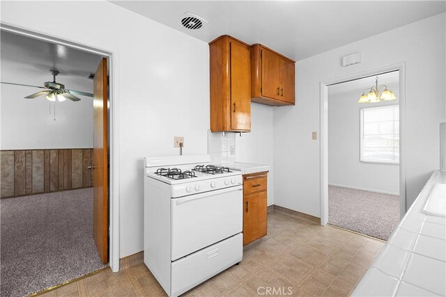 1256 Windsor Dr, San Bernardino, CA 92404 - kitchen with gas range gas stove, light floors, brown cabinets, ceiling fan, and tile counters