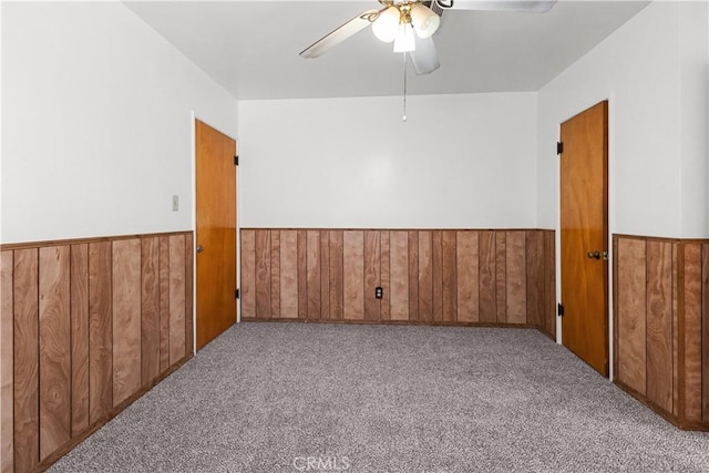 1256 Windsor Dr, San Bernardino, CA 92404 - carpeted empty room with ceiling fan, a wainscoted wall, and wood walls