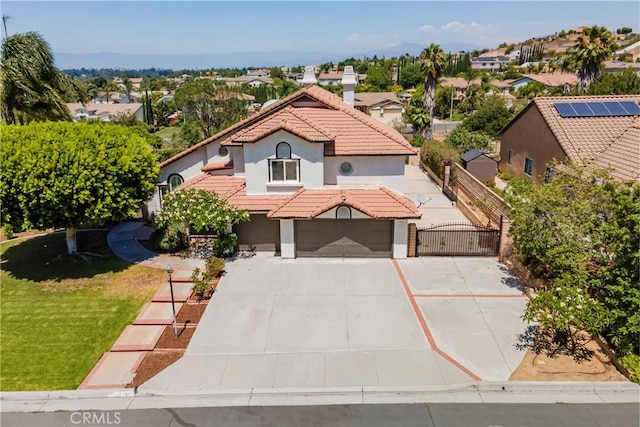 2151 Lyon Ave, Riverside, CA 92503 - mediterranean / spanish home with a tile roof, concrete driveway, a gate, stucco siding, and a residential view