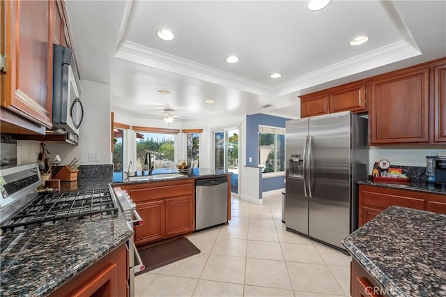 2151 Lyon Ave, Riverside, CA 92503 - kitchen featuring appliances with stainless steel finishes, a raised ceiling, dark stone countertops, light tile patterned flooring, and crown molding