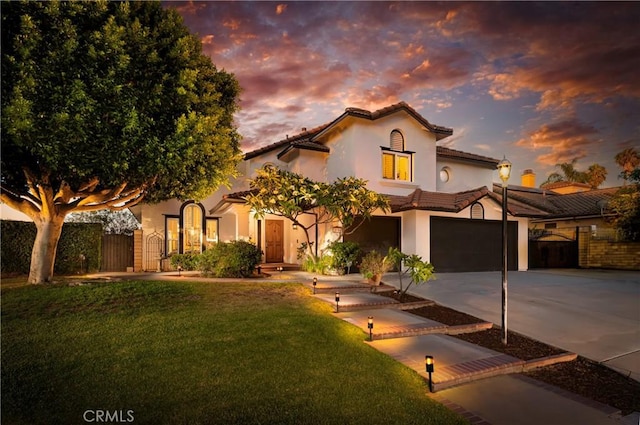 2151 Lyon Ave, Riverside, CA 92503 - mediterranean / spanish house featuring driveway, stucco siding, a tiled roof, and a garage