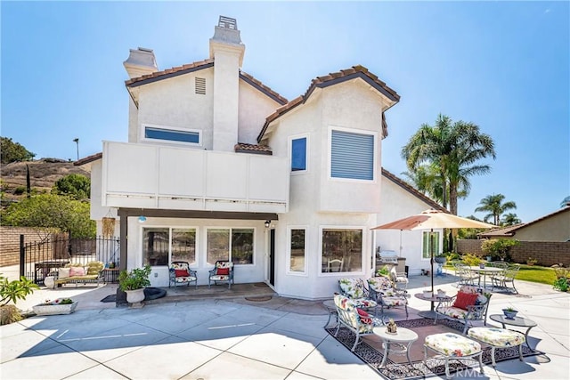 2151 Lyon Ave, Riverside, CA 92503 - back of house with a balcony, a chimney, a patio, and stucco siding