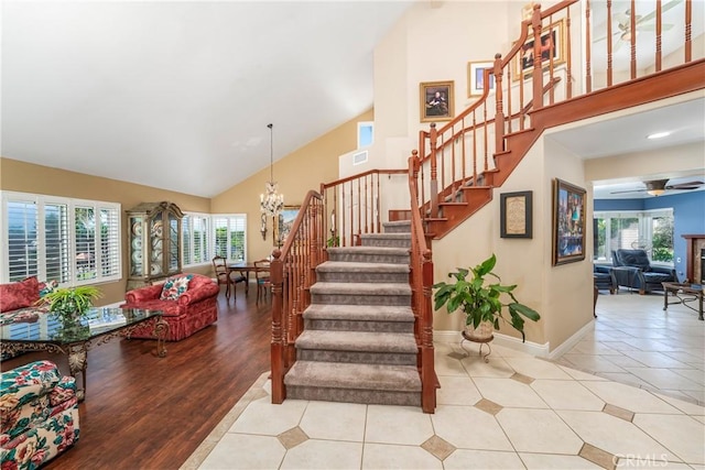 2151 Lyon Ave, Riverside, CA 92503 - staircase featuring a chandelier, plenty of natural light, a ceiling fan, high vaulted ceiling, and tile patterned flooring