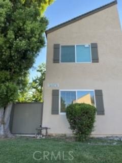 25715 Hogan Dr Unit B1, Valencia, CA 91355 - back of house featuring stucco siding and a lawn