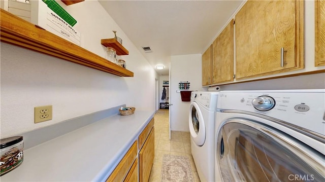 15233 Olive St, Hesperia, CA 92345 - washroom featuring washer and clothes dryer, cabinet space, and light tile patterned floors