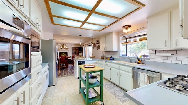 15233 Olive St, Hesperia, CA 92345 - kitchen with appliances with stainless steel finishes, a peninsula, backsplash, and light countertops