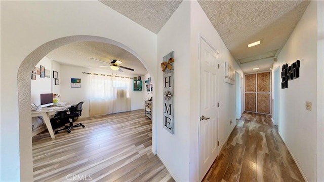 15233 Olive St, Hesperia, CA 92345 - corridor featuring wood finished floors, arched walkways, an office area, and a textured ceiling