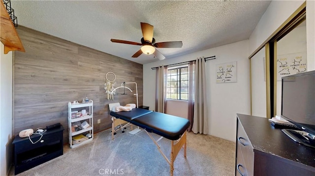 15233 Olive St, Hesperia, CA 92345 - carpeted office with wood walls, a ceiling fan, a textured ceiling, and an accent wall