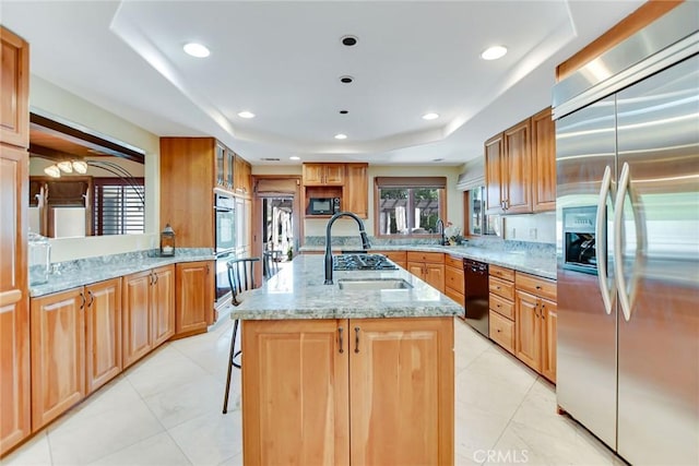 462 Pomello Dr, Claremont, CA 91711 - kitchen with black appliances, light stone counters, an island with sink, a raised ceiling, and a breakfast bar