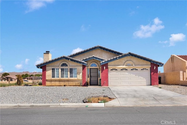 26969 Lakeview Dr, Helendale, CA 92342 - view of front facade with a garage, a chimney, concrete driveway, stucco siding, and a tiled roof