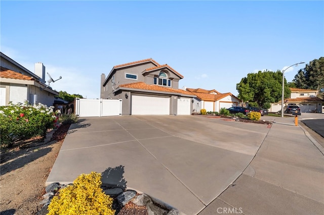40236 Holden Cir, Temecula, CA 92591 - view of front of house featuring a gate, concrete driveway, stucco siding, an attached garage, and a tile roof
