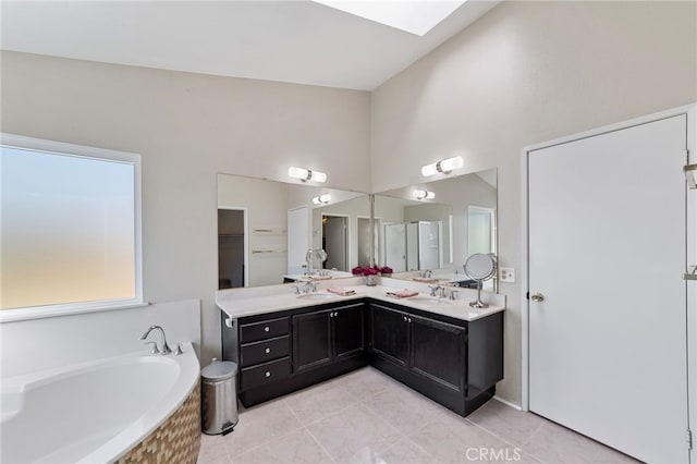 40236 Holden Cir, Temecula, CA 92591 - bathroom featuring tile patterned floors, double vanity, a bath, a towering ceiling, and a skylight