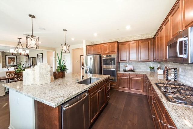 11829 Confluence Dr, Jurupa Valley, CA 91752 - kitchen featuring stainless steel appliances, dark wood-type flooring, light stone counters, a kitchen island with sink, and tasteful backsplash
