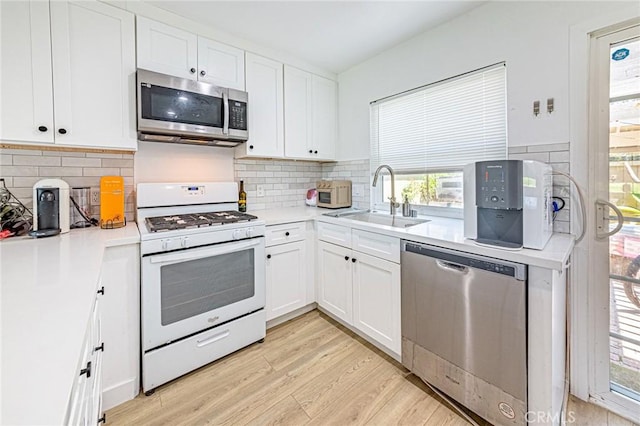 68 Timber Run Unit 45, Irvine, CA 92614 - kitchen featuring stainless steel appliances, light wood finished floors, white cabinets, light countertops, and tasteful backsplash